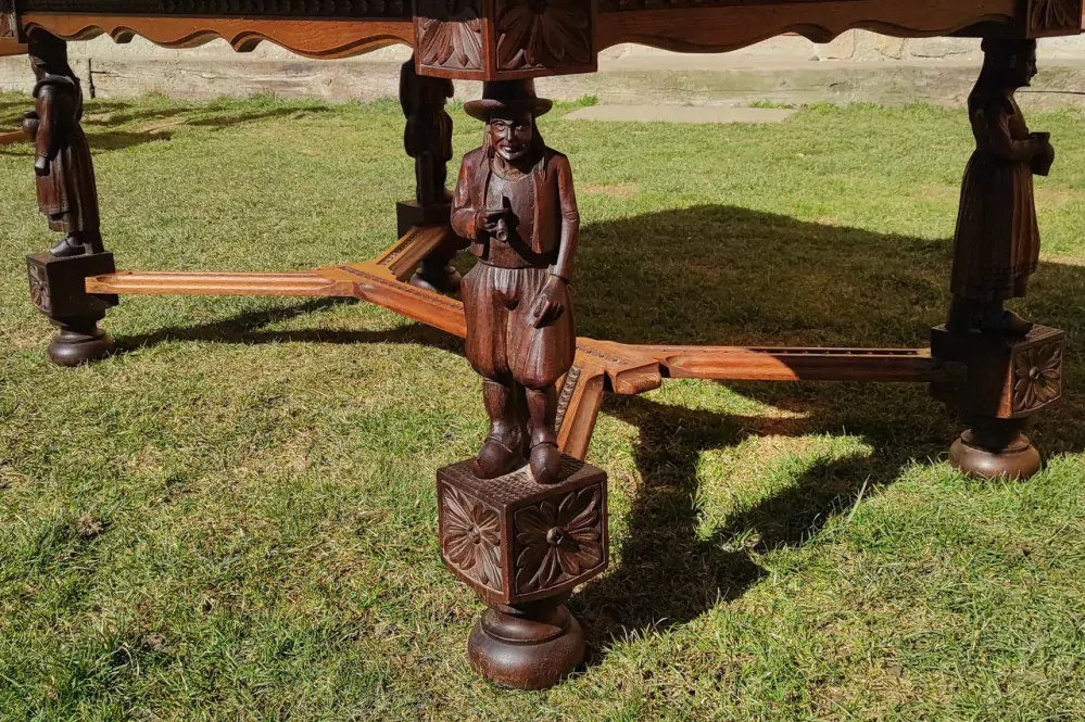 Masivní dubový rozkládací stůl s figurální řezbou